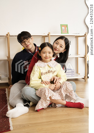 A family sitting with their daughter in arms 126433258