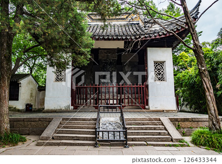 Historic temple courtyard features traditional architecture surrounded by lush greenery in a serene environment Historic temple courtyard features traditional architecture surrounded by lush greenery in a serene environment 126433344