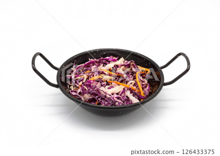 Top view of coleslaw with shredded purple cabbage carrot and white cabbage served in black handled bowl on white background Top view of coleslaw with shredded purple cabbage carrot and white cabbage served in black handled bowl on white background 126433375