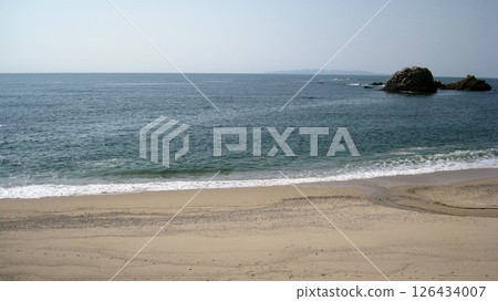 Clear blue sky and white waves crashing on the shore Clear blue sky and white waves crashing on the shore 126434007
