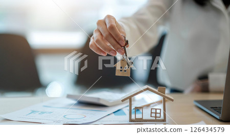 real estate agent holding house key to his client after signing contract,concept for real estate, moving home or renting property 126434579
