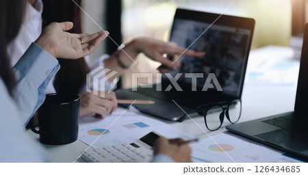 Business concept. Business people discussing the charts and graphs showing the results of their successful teamwork. 126434685