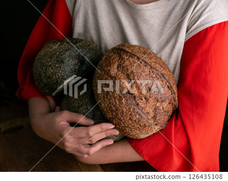 Woman hand hold fresh baked sourdough bread. Presenting Homemade ciabatta bread. 126435108