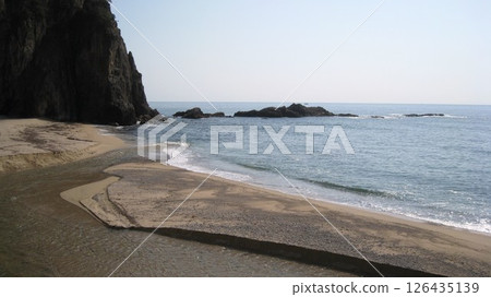 Clear blue sky, blue sea, a cape jutting out from the coast, and a clear river 126435139