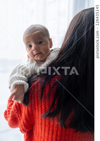 Tender Moment Between Mother and Baby by the Window 126435145