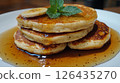 Banana pancakes, maple syrup, mint leaves. 126435270