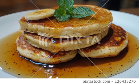 Banana pancakes, maple syrup, mint leaves. Banana pancakes, maple syrup, mint leaves. 126435270