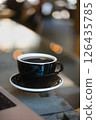 Delicious Black Coffee on a Table Surrounded by a Warm, Cozy Cafe Ambiance and Atmosphere 126435785