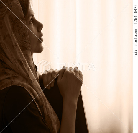 Young girl with bible praying to God Young girl with bible praying to God 126436475