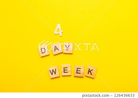 inscription four day week making by wooden cubes on yellow background 126436633