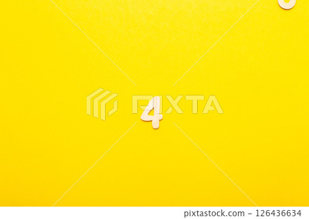 Top view of wooden number 4 four on yellow bright background. Top view of wooden number 4 four on yellow bright background. 126436634