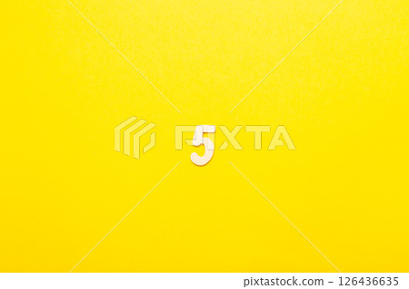 Top view of wooden number 5 five on yellow bright background. Top view of wooden number 5 five on yellow bright background. 126436635