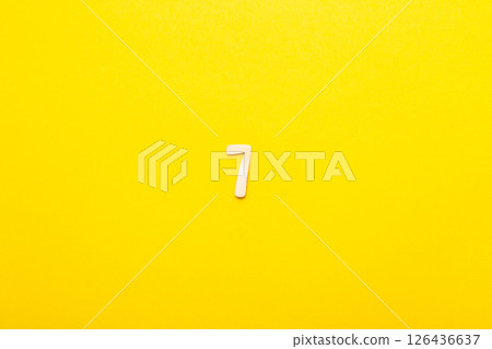 Top view of wooden number 7 seven on yellow bright background. 126436637