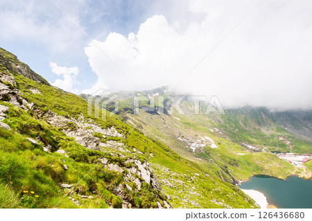 fagaras mountain ridge. vacation season. beautiful summer landscape of romania. sunny day. green rocky cliffs. scenic nature background. balea lake with snow 126436680
