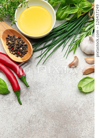 Fresh herbs, spices and olive oil creating culinary inspiration on gray background 126437249