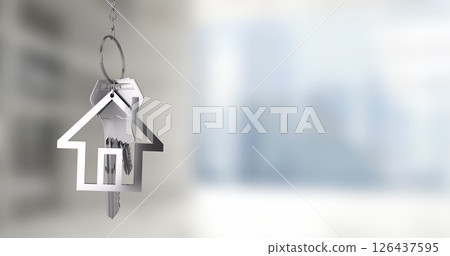 House-shaped keychain with keys over blurred cityscape image 126437595