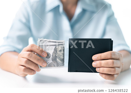 She carefully counted the dollar bills in her hand, managing her business finances and prioritizing saving for future investments. dollar, finance, money, cash, currency, bill, banknote, business. 126438522