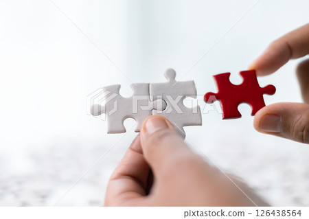 Team with piece of jigsaw puzzle as critical component of business strategy, understanding teamwork and collaboration were essential for achieving success and realizing concept of well-executed plan. Team with piece of jigsaw puzzle as critical component of business strategy, understanding teamwork and collaboration were essential for achieving success and realizing concept of well-executed plan. 126438564