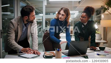 Creative, teamwork or planning with laptop in office at night for marketing campaign, design feedback or brainstorming. Graphic designer, people or discussion for brand development, ideas or overtime 126438905