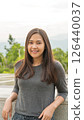 A vertical picture of a young Asian woman traveling. 126440037