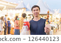 An Asian young man travels with street food. 126440123