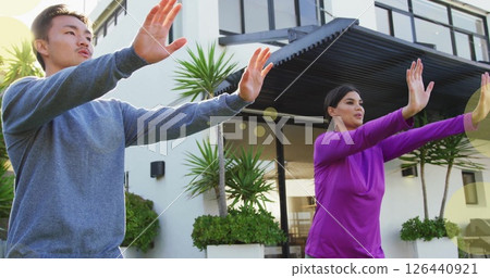Image of spots of light over biracial couple practicing yoga by house 126440921