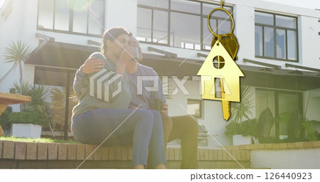 Image of gold house key and key fob over happy biracial couple by house Image of gold house key and key fob over happy biracial couple by house 126440923