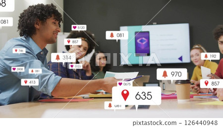 Image of media icons over diverse colleagues discussing work 126440948