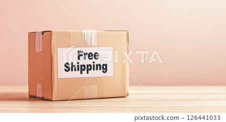 Free Shipping Day concept featuring a cardboard box with a label placed on a wooden surface against a pastel background with copy space. 126441033