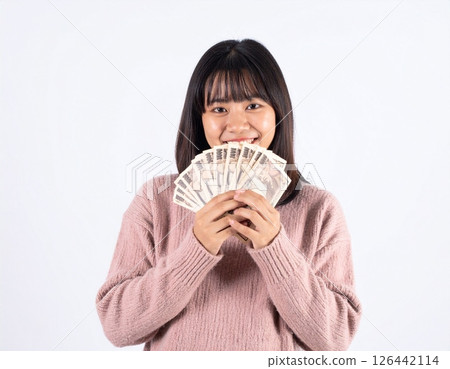 Smiling young woman holding money 126442114