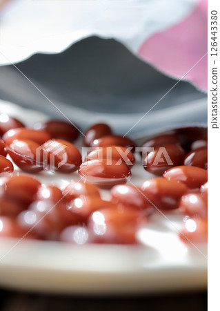 Opened bag and brown pills of placenta supplement 126443380