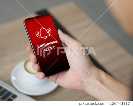 Earthquake alert warning displayed on smartphone screen as symbol, telling people to be careful. Technology concept 126443817
