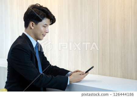 Digital Life Exploration. Businessman in suit and tie typing text message on mobile phone. Digital Life Exploration. Businessman in suit and tie typing text message on mobile phone. 126444186