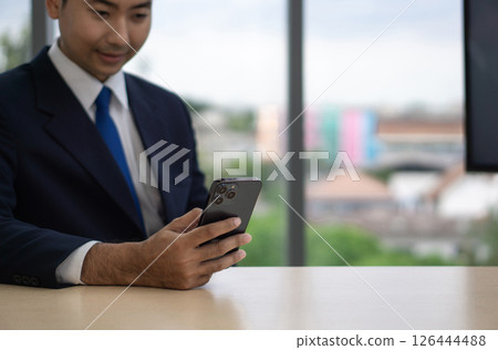 Digital Life Exploration. A focused businessman in dark blue suit reading text message on mobile phone. Digital Life Exploration. A focused businessman in dark blue suit reading text message on mobile phone. 126444488