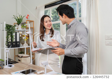 ESG Business Engagement. Professionals excitedly discussing renewable energy strategies in a bright workspace. ESG Business Engagement. Professionals excitedly discussing renewable energy strategies in a bright workspace. 126445732