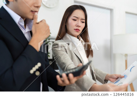 Business Discussion and Analysis. Professionals reviewing data charts and reports in office setting. 126445816