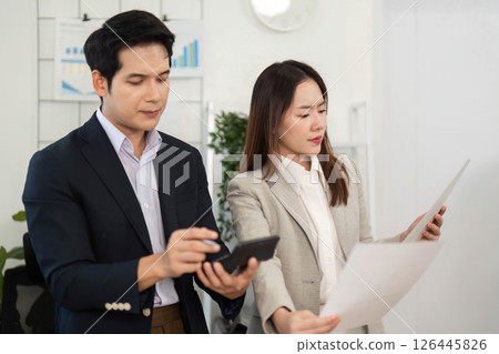 Business Collaboration and Strategy. Professionals reviewing project documents in modern office. Business Collaboration and Strategy. Professionals reviewing project documents in modern office. 126445826