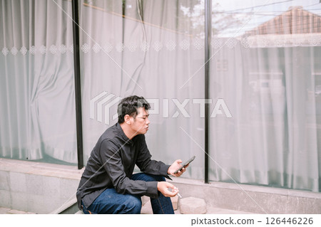 Thoughtful man smoking, contemplative pose in neutral environment 126446226