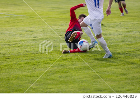 Football players at the stadium with the ball score a goal to the goalkeeper 126446829
