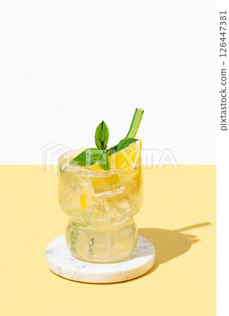 Fresh mocktail mojito with lemon, mint and ice. Citrus lemonade on a white yellow background. Fresh mocktail mojito with lemon, mint and ice. Citrus lemonade on a white yellow background. 126447381