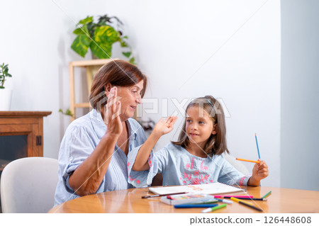 Grandmother giving high five to girl with colored 126448608