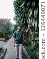 a man in a garden is standing on a walkway 126449071