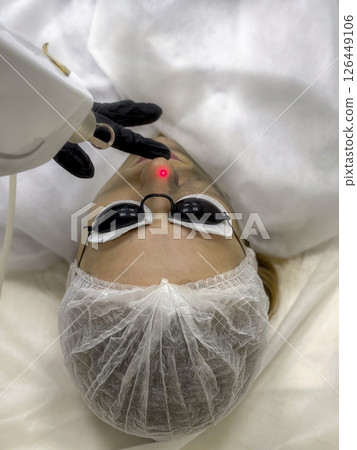 Carbon face peeling procedure. Laser pulses clean skin of the face. Carbon face peeling procedure. Laser pulses clean skin of the face. 126449106
