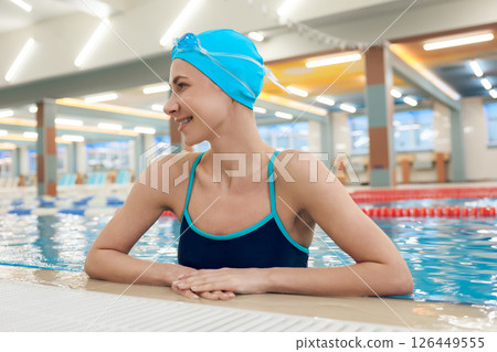 Waist up of a young pretty woman in the pool looking enjoyed 126449555