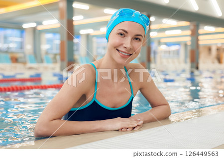 Waist up of a young pretty woman in the pool looking enjoyed Waist up of a young pretty woman in the pool looking enjoyed 126449563