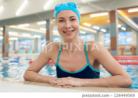 Waist up of a young pretty woman in the pool looking enjoyed Waist up of a young pretty woman in the pool looking enjoyed 126449569