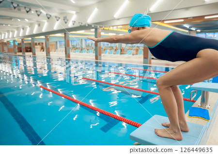 Woman in swimsuit preparing to jump into water in the swimming pool 126449635