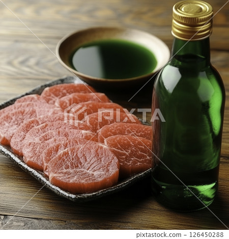 Fresh Slices of Beef with Green Sauce on Wooden Table in Rustic Kitchen Setting 126450288
