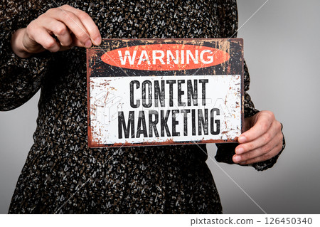 Content Marketing Concept. Warning Sign Held by Person on Neutral Background 126450340