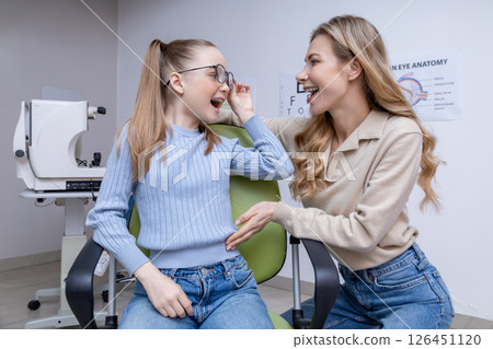 Mom and kid at the ophthalmologist office feeling contented 126451120